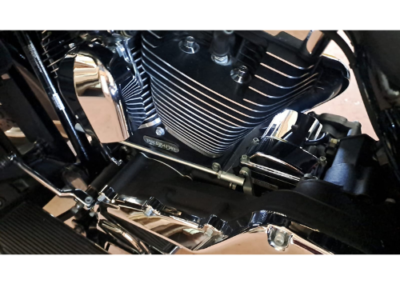 Close-up of a motorcycle engine with black cooling fins and chrome detailing, showing the cylinders and exhaust components